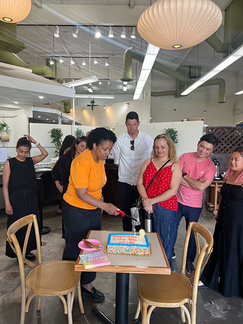 Rising Tide Pasadena members lighting a candle on the birthday cake